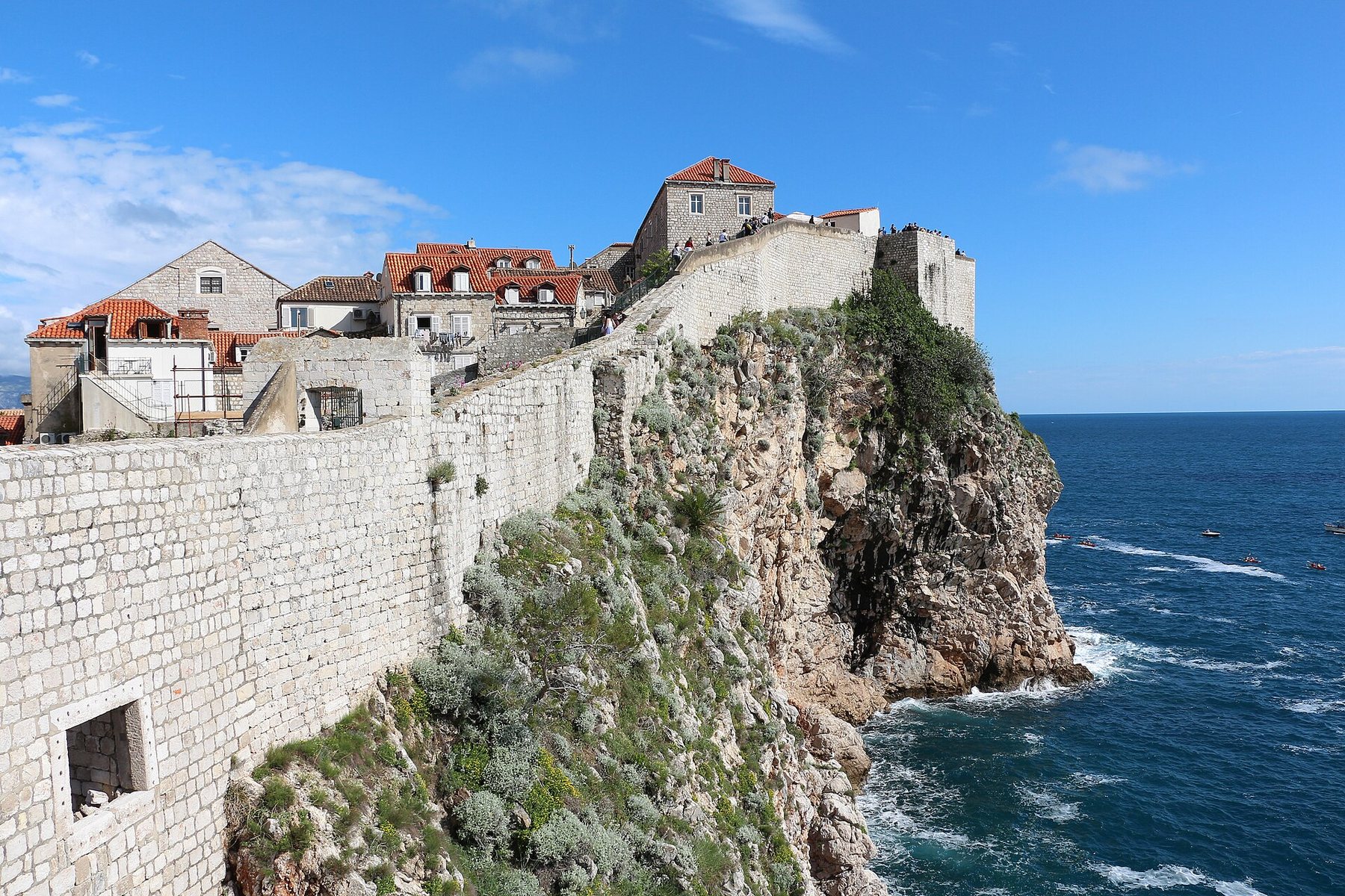Stone city walls surrounding Dubrovnik Old Town beside the Adriatic