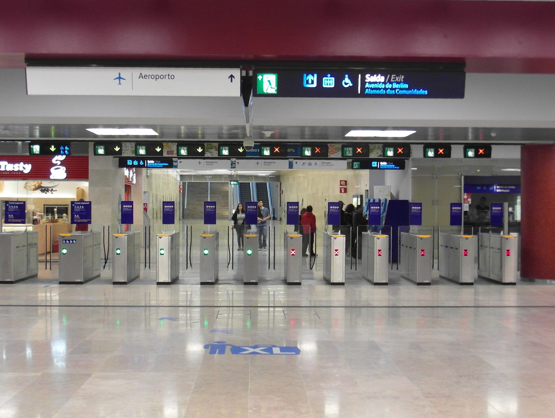 Ticket gates and exit signs in the concourse of Aeroporto metro station in Lisbon