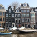 Traditional canal houses and boats beside an Amsterdam canal
