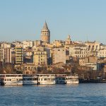 Galata Tower rising above the Karaköy waterfront and ferries on the Golden Horn