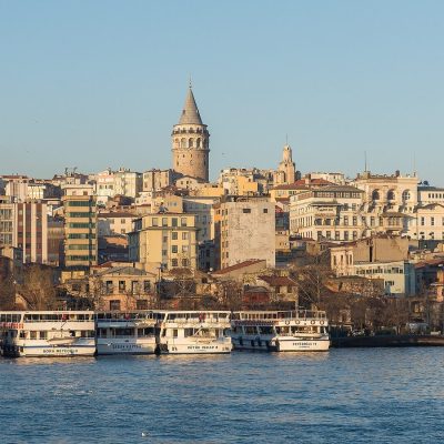 Galata Tower rising above the Karaköy waterfront and ferries on the Golden Horn