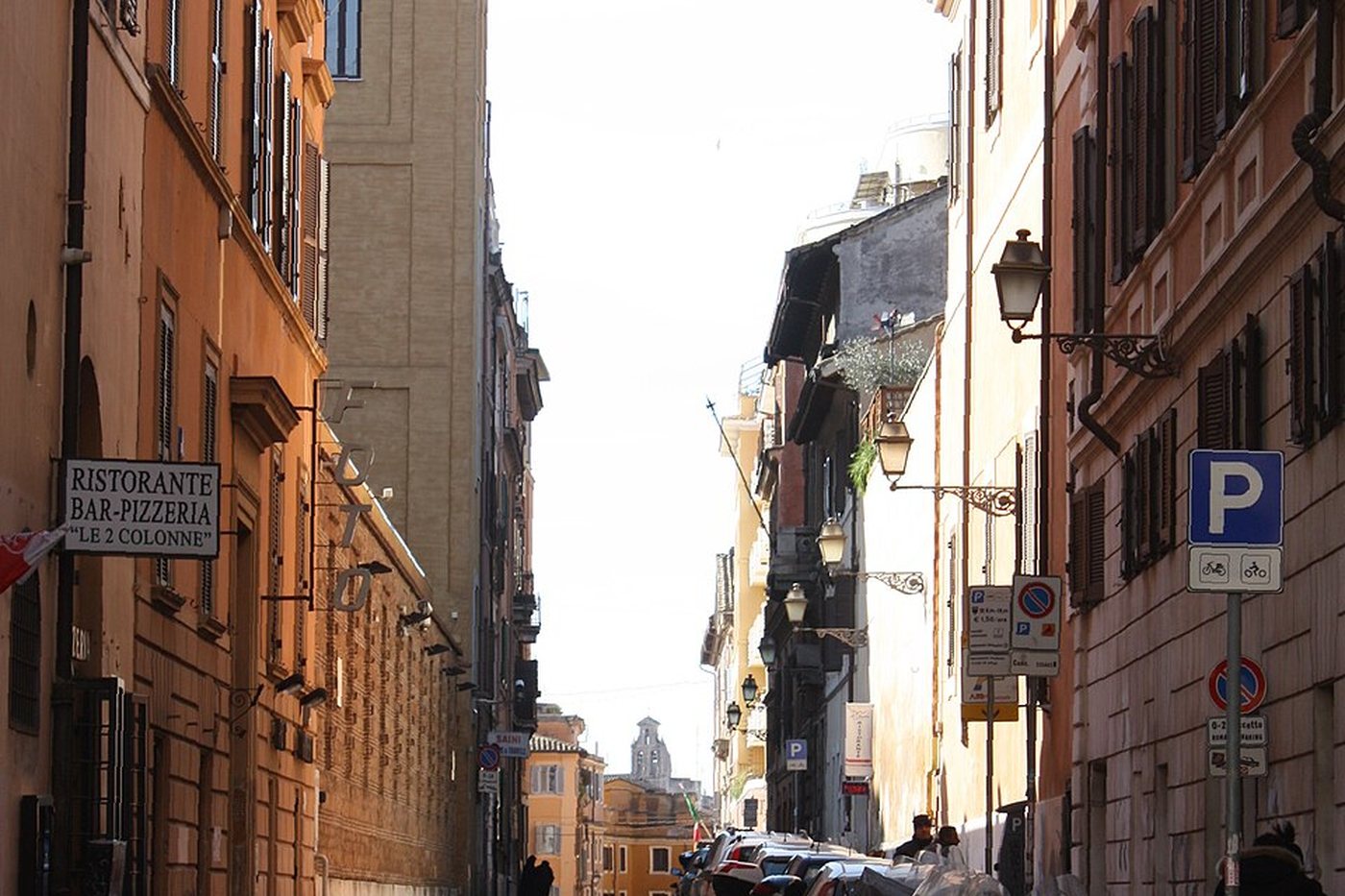 A narrow street lined with ochre buildings in Monti, Rome