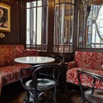 Red upholstered booths and marble tables inside Café Sperl in Vienna