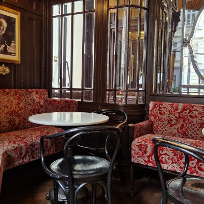 Red upholstered booths and marble tables inside Café Sperl in Vienna