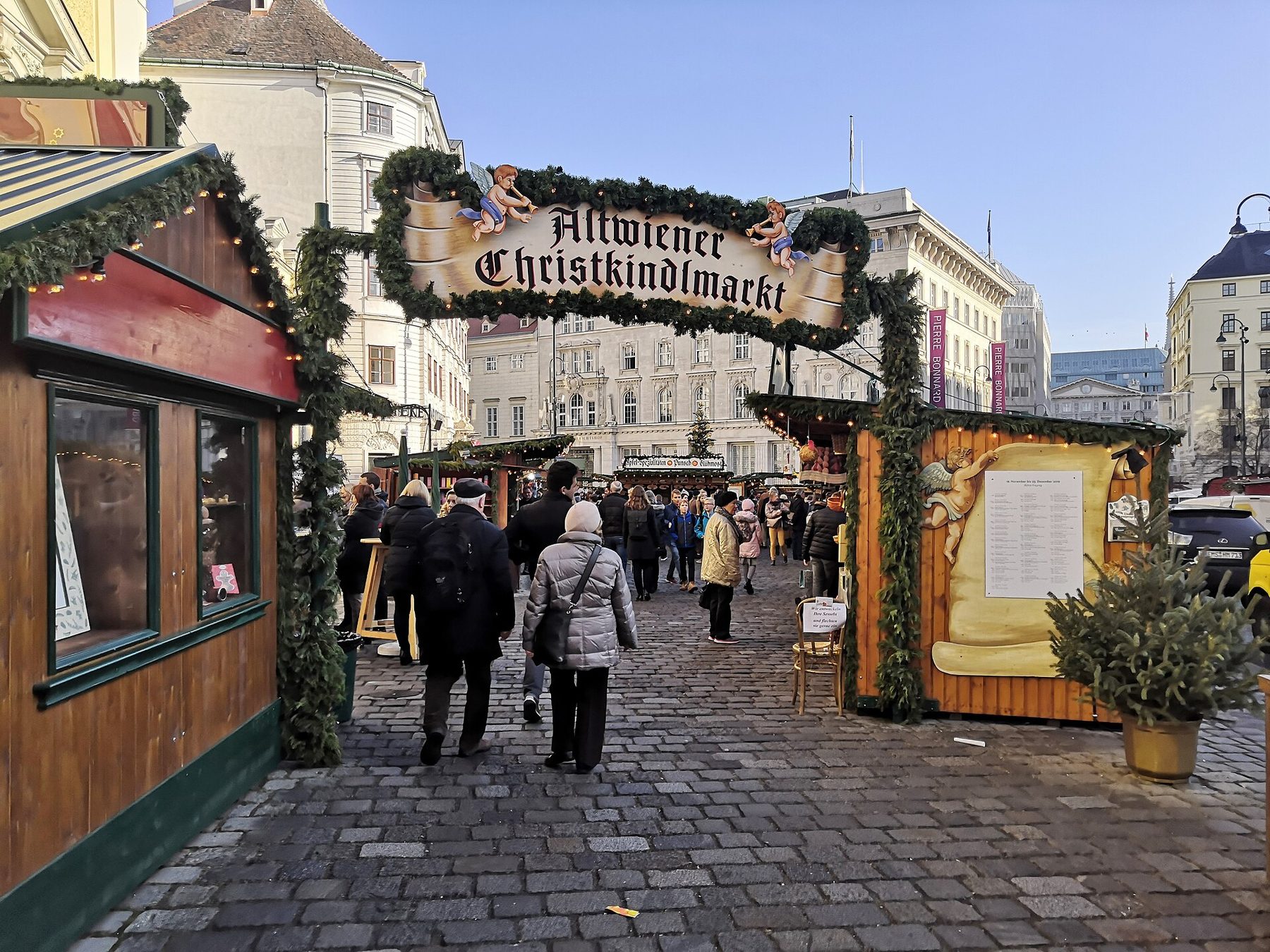 Entrance arch of the Altwiener Christkindlmarkt and wooden stalls on the Freyung square in central Vienna